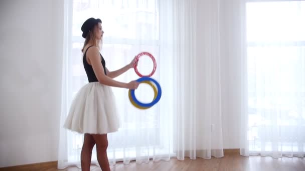 Νεαρή γυναίκα μπαλαρίνα ζογκλέρ με έναν κύκλο πραγμάτων - Πλάνα, βίντεο