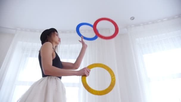 Молодая балерина жонглирует объектами круга в яркой студии
 - Кадры, видео