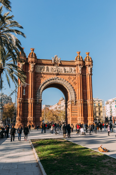 BARCELONA, SPAIN - DECEMBER 28, 2018: Arc de Triomf, famous city landmark, and people walking along wide alley - 写真・画像
