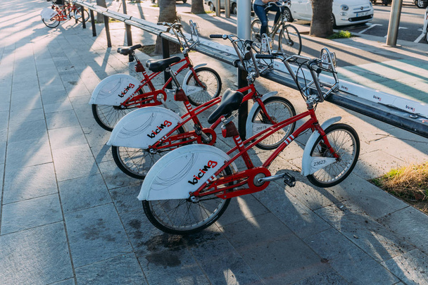 BARCELONA, ESPAÑA - 28 DE DICIEMBRE DE 2018: estacionamiento de bicicletas en el soleado pavimento de la calle
 - Foto, Imagen
