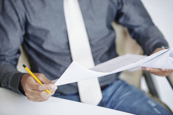 Крупним планом образ бізнесмена, який читає важливий документ в руках
 - Фото, зображення