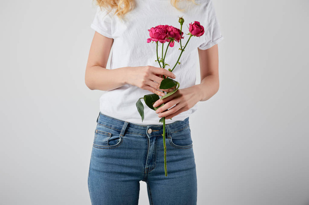 cropped view of girl holding pink roses isolated on grey - Photo, Image