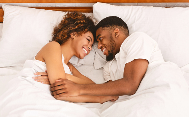 A fiatal szerető fekete pár, ágyban fekve, felülnézet - Fotó, kép