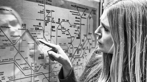 Νεαρή γυναίκα που ψάχνει για ένα χάρτη του μετρό. - Φωτογραφία, εικόνα