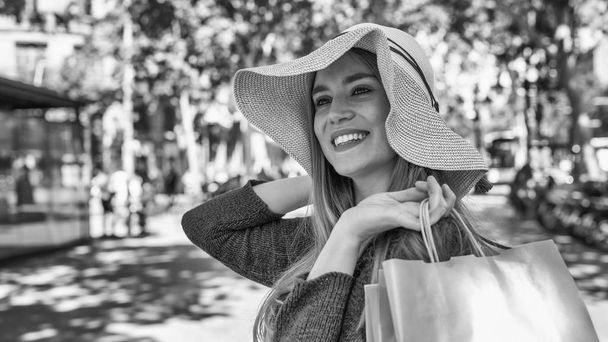Happy young woman with straw hat visiting city. - Foto, Imagen