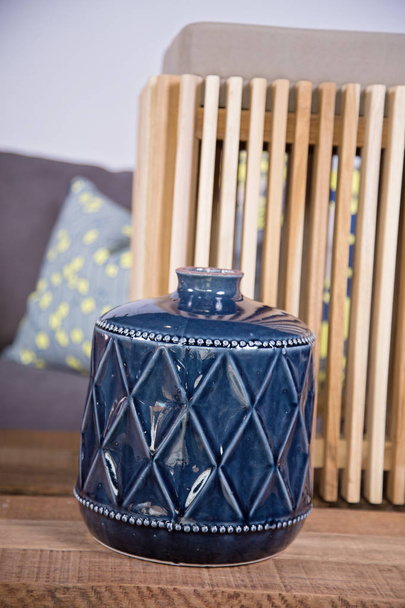 Details der Innendekoration mit kupfernen und braunen Holzstrukturen und blauer Vase - Foto, Bild