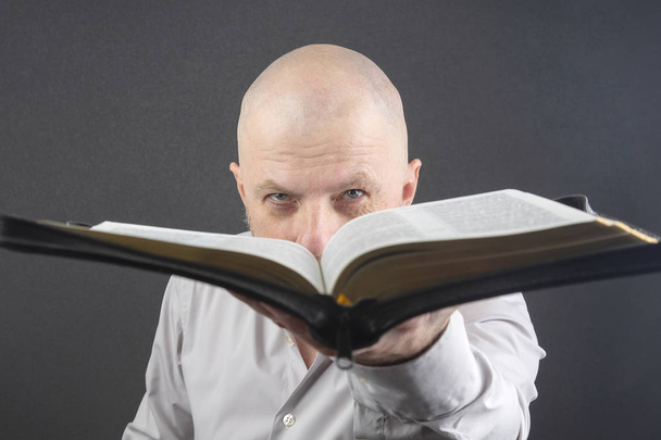 man looks through an open Bible - Photo, Image