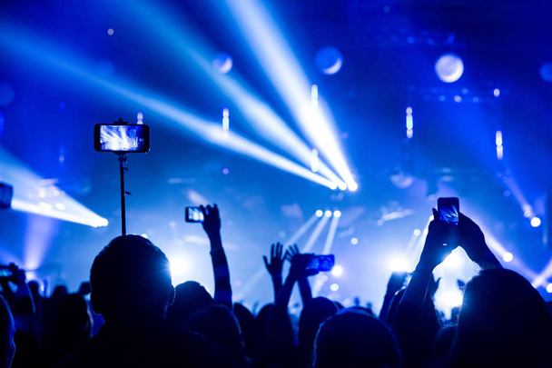 Siluetas de multitudes de espectadores en un concierto con smartphones en sus manos
. - Foto, Imagen