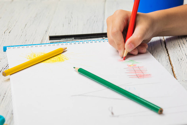 Детский рисунок и много карандашей для рисования на деревянной спинке
 - Фото, изображение