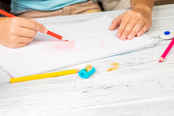 Mano de niños dibujando corazón rojo con lápiz de color en blanco
  - Foto, Imagen