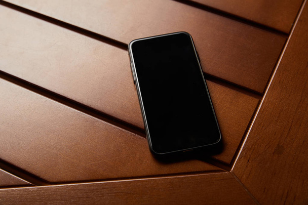 smartphone with blank screen and copy space on wooden surface - Foto, Imagen