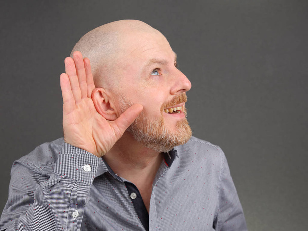 человек поднял уши к слуху своей рукой
 - Фото, изображение