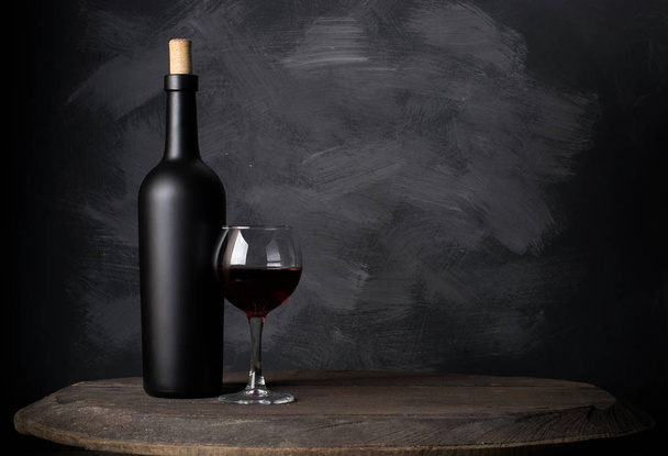 Red wine bottle on a wooden background - Fotografie, Obrázek
