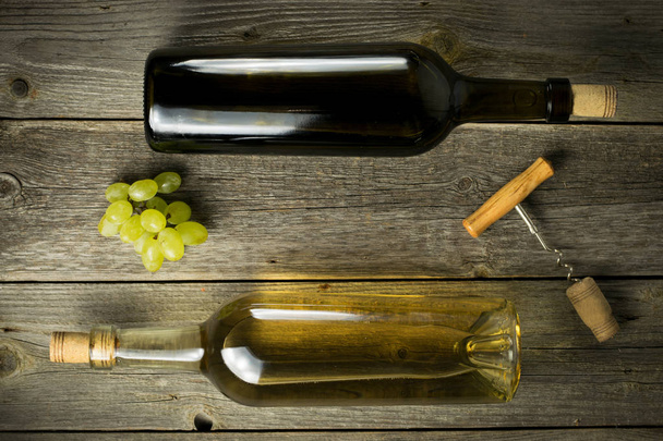 Glass bottle of wine with corks on wooden table background - Foto, imagen