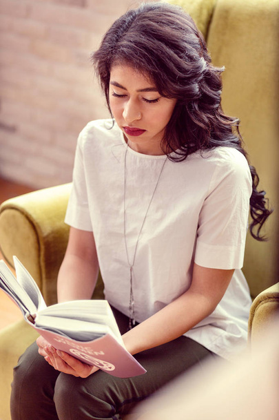 Top view of a serious smart woman reading - Φωτογραφία, εικόνα