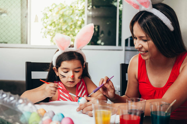 Happy easter! A mother and her daughter painting Easter eggs. Ha - Fotoğraf, Görsel