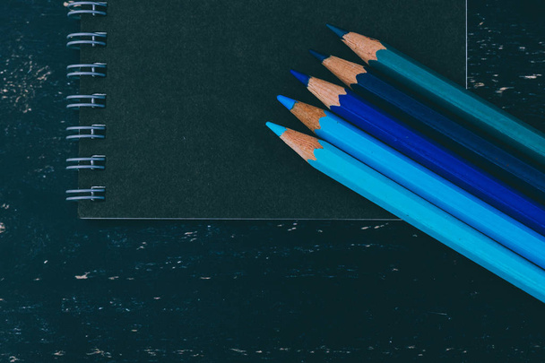 escritorio negro con bloc de notas negro y lápices de color con watercolou
 - Foto, imagen