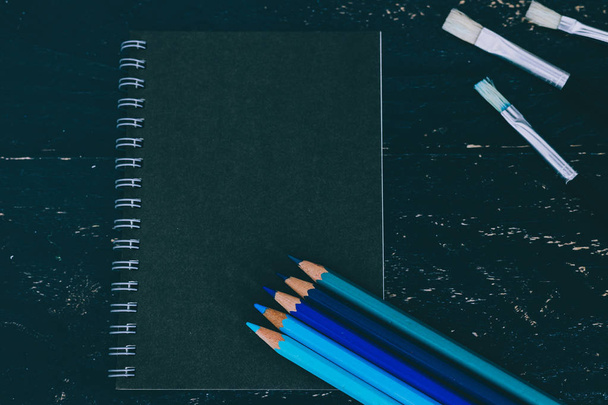 bureau noir avec bloc-notes noir et crayons de couleur avec aquarelle
 - Photo, image