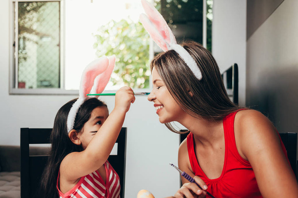 Happy easter! A mother and her daughter painting Easter eggs. Ha - Φωτογραφία, εικόνα