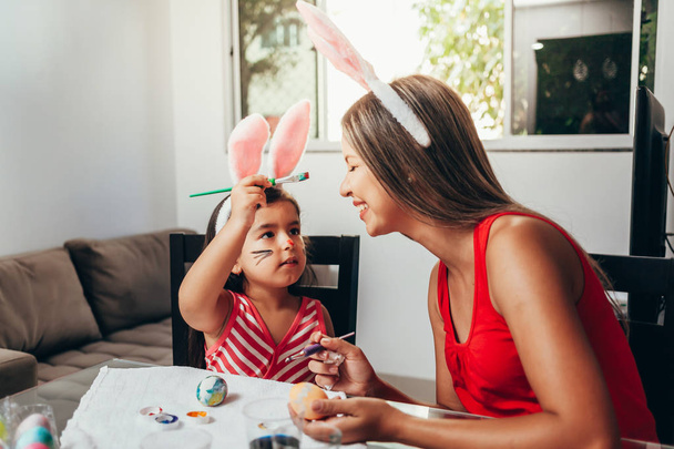 Happy easter! A mother and her daughter painting Easter eggs. Ha - Foto, imagen
