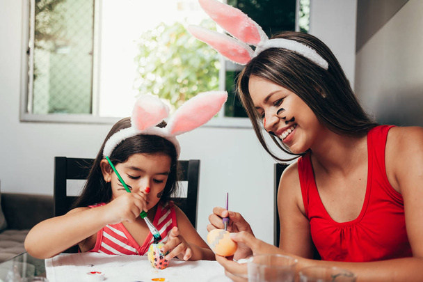 Happy easter! A mother and her daughter painting Easter eggs. Ha - Foto, Bild