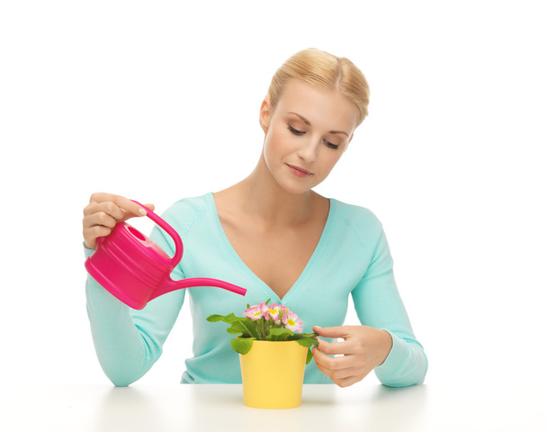 Housewife with flower in pot and watering can - Foto, Imagen