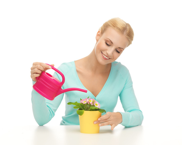 Dona de casa com flor em vaso e regador de lata
 - Foto, Imagem