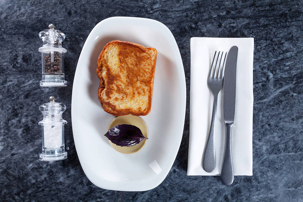 Top view on traditional breakfast food. European cuisine. Fried toast with pate on white plate on marble table overhead. Picture for design with copy space. Flat lay - Foto, afbeelding