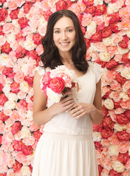 Woman with bouquet and background full of roses - Foto, Imagem