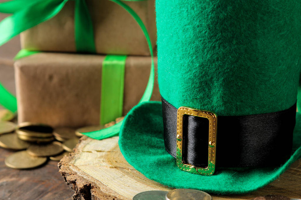 Día de San Patricio. celebración. Verde sombrero de duende y el dinero de cerca sobre un fondo marrón
. - Foto, imagen