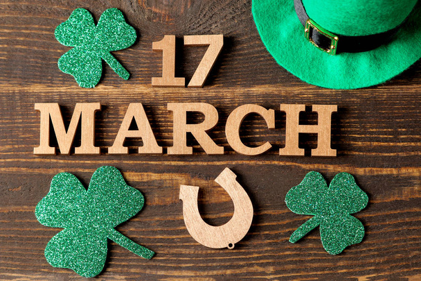 St.Patrick'ın gün. kutlama. kahverengi zemin üzerine yeşil yaprakları yonca ve at nalı ve 17 Mart metni. Üstten Görünüm. - Fotoğraf, Görsel