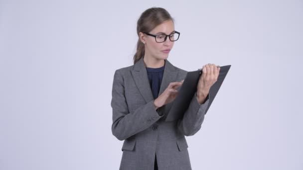 Young happy businesswoman giving thumbs up while showing clipboard - Video, Çekim