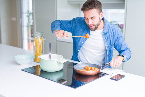 Komea mies ruoanlaitto pasta kotona - Valokuva, kuva