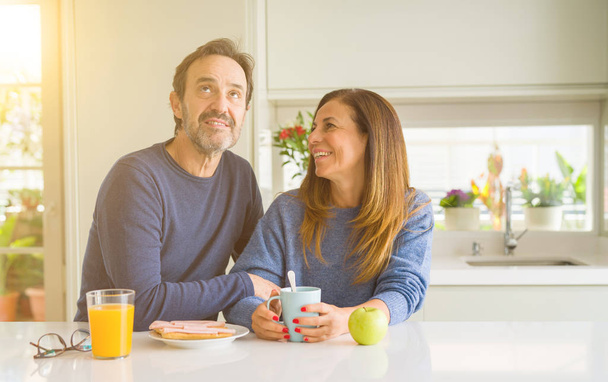 Beautiful romantic middle age couple having healthy breaskfast in the morning at home - Photo, Image