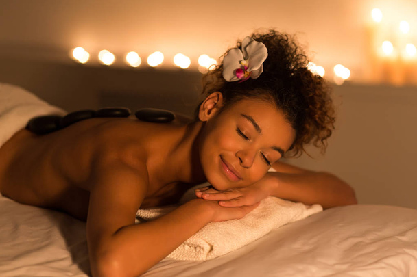 Kobieta korzystających kamienie z powrotem masaż w salonie spa - Zdjęcie, obraz