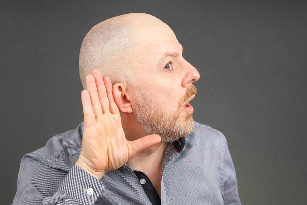 чоловік підняв вуха на слухання своєю рукою
 - Фото, зображення