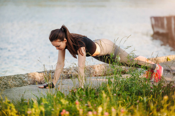 young athletic woman push-UPS in Park near lake - Foto, afbeelding