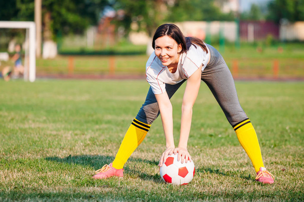 happy smile woman with soccer ball on football pitch. holding in - Fotografie, Obrázek