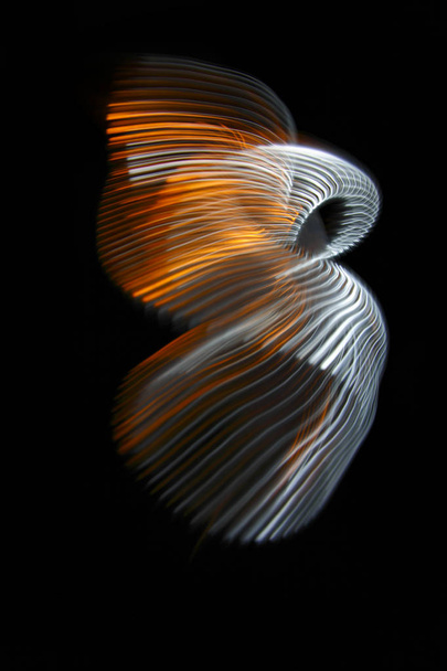 Multicolored twisted ordered parallel lines on a black background. Light in motion. Color abstraction. - Fotó, kép