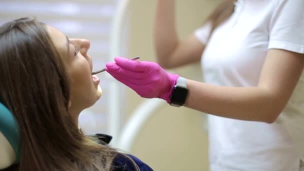 Tandarts behandeling tanden aan vrouw patiënt in kliniek. - Video