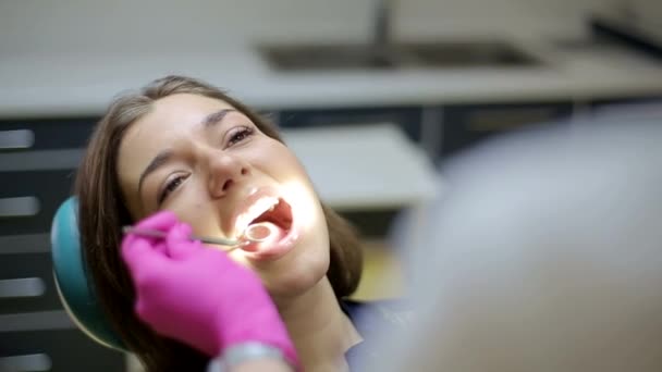 Νεαρή γυναίκα μιλάει με τον οδοντίατρό σου στο οδοντιατρείο, κορίτσι οδοντίατρος - Πλάνα, βίντεο