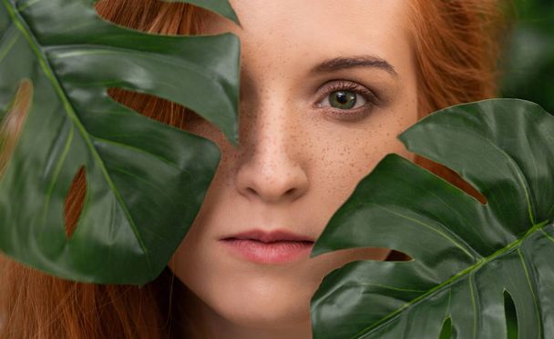 Portrait of young and beautiful woman in tropical leaves - 写真・画像