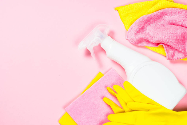 Aerozol do czyszczenia, tkaniny i rękawice na różowym tle. - Zdjęcie, obraz