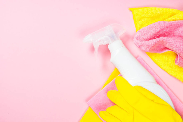 Spray nettoyant, chiffon et gants sur fond rose
. - Photo, image