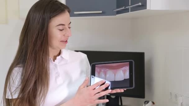 Dentista ragazza dice come prendersi cura correttamente per i denti - Filmati, video