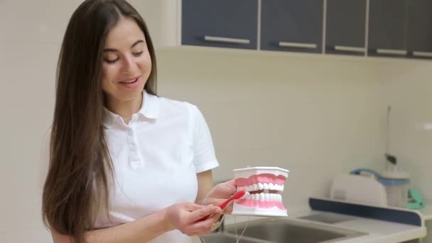 Dívka zubař ukazuje, jak si vyčistit zuby - Záběry, video