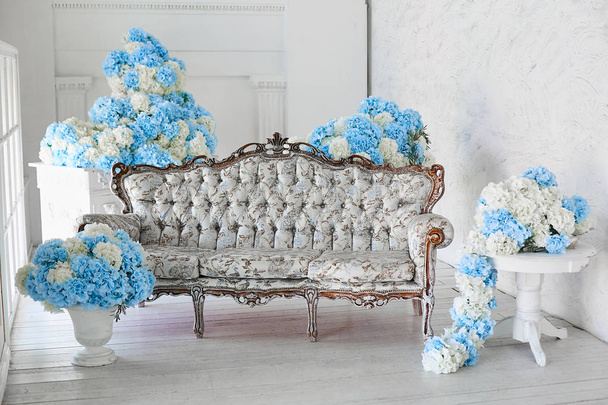 Modern belső terekkel. Arany díszítéssel, fehér és kék színek körülvett luxus kanapé. - Fotó, kép