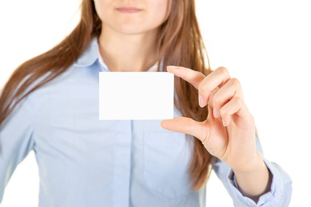 joven mujer sobre grunge gris pared celebración de la tarjeta de visita de negocios en blanco en la mano
 - Foto, Imagen