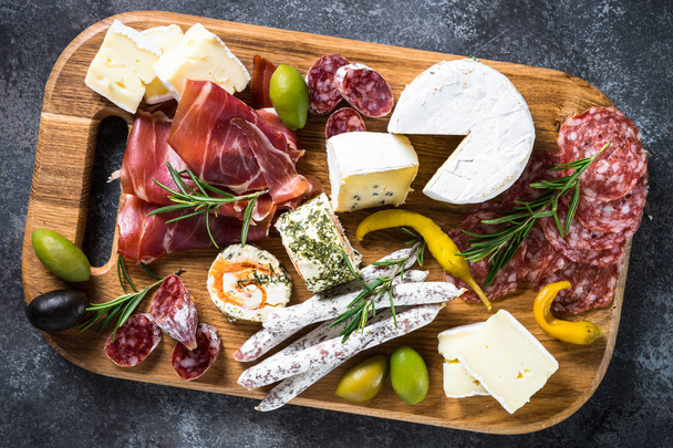 Антипасто - нарізане м'ясо, шинка, салямі, сир, оливки на дерев'яній б
 - Фото, зображення