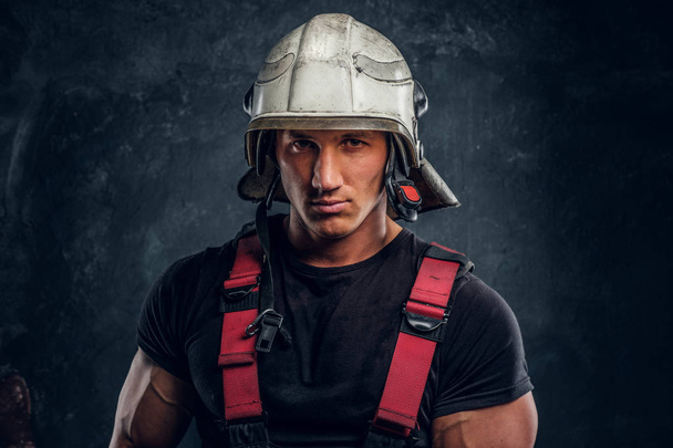 Portrét pohledný muž nosí požární přilba a rukavice, při pohledu na fotoaparát - Fotografie, Obrázek
